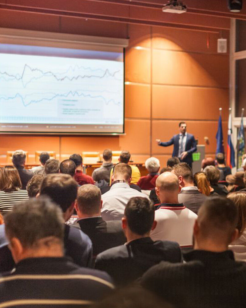 Business professional presenting financial trends to an audience of business owners.